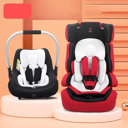 Two car seats, one black and white, one red and white, on a peach-colored background.